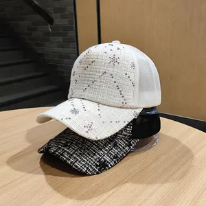 Primo piano di berretti da baseball in tweed e paillettes con dettagli raffinati e tessuto traspirante.