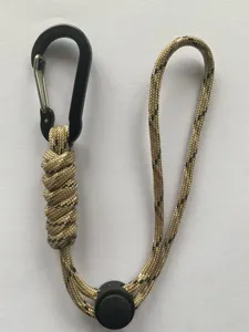 Paracord lanyard detail showing the khaki woven rope, metal carabiner, and black plastic buckle.