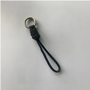 Detalle correa llavero paracord negro con textura tejida muy duradera y un anillo metálico.