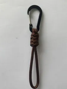 Close-up detail shot showing the brown paracord lanyard and black metal carabiner hook.