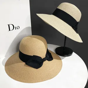 Vue détaillée du chapeau de paille d'été à large bord et nœud noir, protection solaire élégante.
