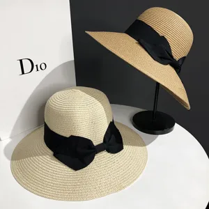 Vue détaillée et élégante du chapeau de paille d'été avec un nœud noir sur le présentoir.