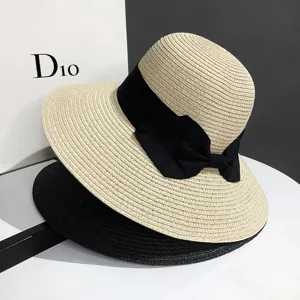 Chapeau de paille elegant a larges bords avec noeud noir pour vacances et protection solaire.