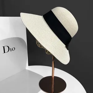 Vue détaillée du chapeau de paille à large bord avec ruban noir pour la protection solaire.