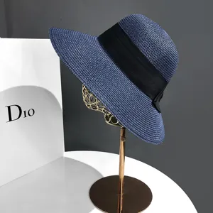 Detail chapeau de paille bleu marine, grand bord protection solaire avec ruban noir.
