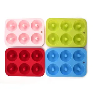 Detail shot showing four colorful 6-cavity silicone donut molds in pink, green, red and blue.