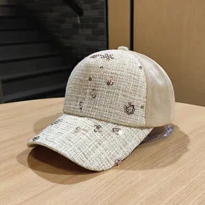 Primo piano di berretto da baseball in tweed beige con fiori di paillettes e retro in rete.