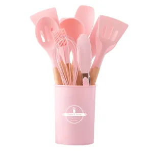 Pink silicone kitchen utensils set with wooden handles and storage bucket for cooking.
