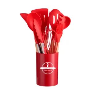 Detail view of red silicone kitchen utensils set with wooden handles and storage holder.