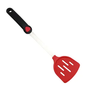 Detail view of the red silicone slotted spatula with stainless steel handle for cooking.