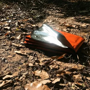 Vue détaillée du tapis de sol isolant en feuille d'aluminium de camping avec surface réfléchissante.