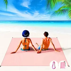 Detail view of portable waterproof pink beach blanket with storage bag and carabiner for outdoor.