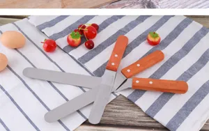 Spatule à gâteau en acier inoxydable avec manche en bois pour la pâtisserie. Vue détaillée.