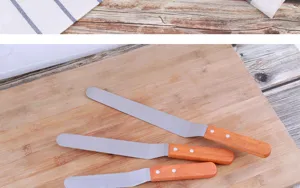 Vue détaillée de la spatule coudée en acier inoxydable avec manche en bois pour pâtisserie.