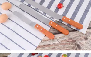 Vue détaillée de spatules à gâteau en acier inoxydable avec des poignées en bois.