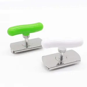 Stainless steel jar opener detail view, ergonomic T-handle design in green and white colors.