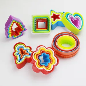Colorful plastic cookie cutters set, detail view of nested shapes for baking and fruit cutting.