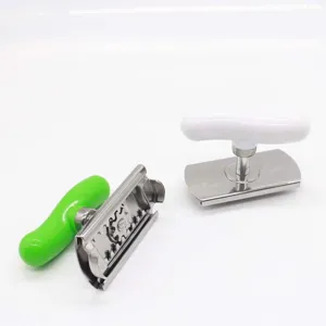 Stainless steel manual can opener featuring green and white plastic handles kitchen tool.