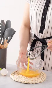 Gros-plan d'un ensemble d'ustensiles de cuisine en silicone avec manches en bois.