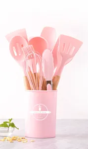 Ensemble d'ustensiles de cuisine en silicone rose avec manche en bois, antiadhésif et seau.
