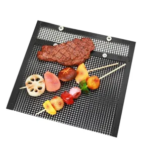 Detail view of non-stick BBQ mesh grill bag with steak and vegetable skewers for outdoor cooking.