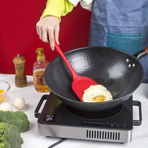 Red silicone cooking spatula for non-stick pans, heat resistant kitchen utensil for frying.