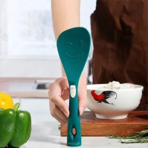 Espátula de cocina de silicona verde con diseño de cara sonriente, utensilio resistente al calor.