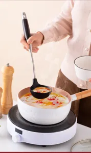 Detailed view of the 304 stainless steel silicone soup ladle in kitchen cooking use.