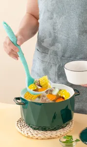 Mint green speckled silicone soup ladle, detail shot showing kitchen cooking scene.