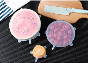 Silicone stretch lids 6-piece set covering fresh food fruits on kitchen table detail.