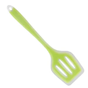 Green silicone slotted spatula detail view, flexible cooking utensil with hanging hole.