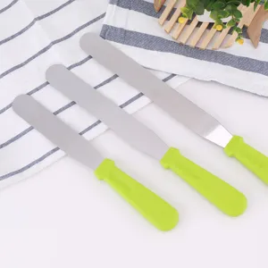 Detailed view of the stainless steel cake spatula featuring a green plastic handle.