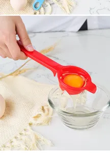 Handheld plastic egg separator in vibrant red color with hanging ear for kitchen baking use.