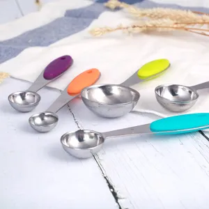 Stainless steel measuring spoons set with colorful silicone handles for kitchen baking use.