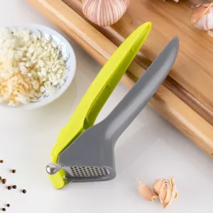 Ergonomic plastic handle garlic press with stainless steel chamber for kitchen use.