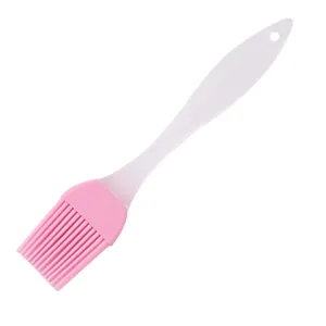 Silicone pastry brush detail view, pink head and white handle with hanging hole for baking.