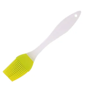 Silicone pastry brush with white handle and yellow bristles for baking and BBQ.