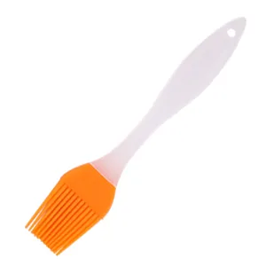 Silicone pastry basting brush detail view, orange head and white handle for baking BBQ.