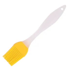 Detailed view of silicone basting brush with bright yellow head and white handle.