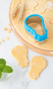 Stainless steel cookie cutter detail view, blue rim design on rolling dough board.