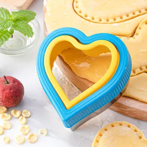 Heart shaped cookie cutter with blue yellow plastic handle for baking pastry and dough.