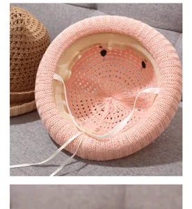 Pink knitted baby sun hat detail view, breathable hollow-out summer kids straw hat with strap.