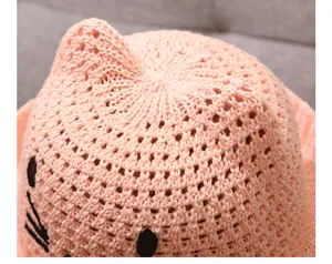Cute pink knitted baby sun hat detail shot, breathable summer hollow design for infants.
