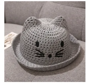 Grey knitted baby sun hat detail showing cute cat ears and embroidered face design, breathable mesh.