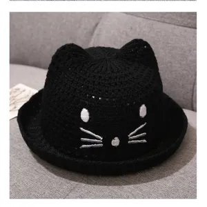 Close-up detail view of black baby knitted sun hat with cute cat ears and fine embroidery texture.