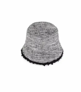 Primo piano dettagliato del cappello da pescatore in tweed bianco e nero con bordo a frange.