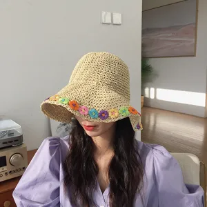 Dettaglio ravvicinato del cappello di paglia fatto a mano con fiori colorati estivi.