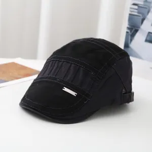 Detailansicht einer schwarzen Vintage Schiebermütze mit Metall-Logo und feinen Stoffnähten.