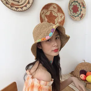 Vista dettagliata di un cappello di paglia intrecciato con fiori colorati per l'estate.