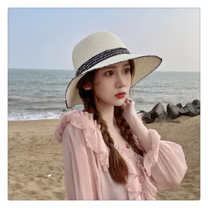 Elegante sombrero de paja con cinta negra, perfecto para vacaciones de verano en la playa.